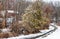 Winter snow on curving driveway leading to red barn