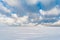 Winter snowfield and cloudy sky with large clouds, winter nature