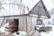 Winter is snowing. A male farmer carries dry reeds in a barn. Rural landscape