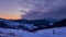 Winter snowy frosty landscape with fence, colorful moving red clouds