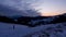 Winter snowy frosty landscape with fence, colorful moving red clouds ,, dusk over snowy landscape