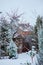 Winter snowy garden view with wood shed and fence