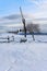 Winter snowy rustic scenic landscape with a draw well and footprints