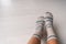 Winter socks woman wearing wool socks at home on hardwood floor. Warm heat inside apartment concept, floor heating feet