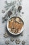 Winter spices on white plate with fir green, pine cones and wooden snowflakes on pale grey kitchen table. Mulled wine preparation