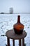 Winter still life on field with table and ancient bottle