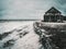 Winter storm day at sea. Dramatic seascape with a raging White sea and a fishing hut on the shore. Kandalaksha bay