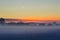 Winter sunset with low fog and frozen fields