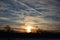 Winter sunset over field with wispy clouds.