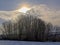 Winter sunset over snow covered fields with trees in the Flemish countryside