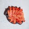 Winter supplies: slices of dried watermelon in wooden plate on white background with deep shadow