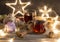 Winter tea party with dessert in a glass capsule on a wooden table. Christmas lights garland of stars, walnuts and cinnamon sticks