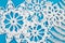 Winter theme white crochet snowflakes on light blue background.