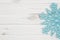 Winter time background with teal snowflake on weathered wood