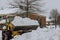 The winter time clean-up of snow following a huge snowstorm with a tractor after a huge snowstorm blasts through the