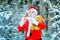 Winter time. Merry Christmas and happy holidays. Santa Claus blowing magic snow of his hands. Photo of Santa Claus