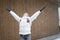 Winter time. Young happy caucasian girl wearing white jacket enjoying first snow with rised hands