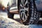 Winter tire close up on a car wheel navigating snowy road