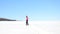 Winter tourist with snowshoes walk in snowy drift. Hiker in pink sports jacket and black trekking trousers snowshoeing in snow