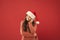 Winter traditions. Adorable girl with long curly hair wear santa claus hat red background. Counting days till christmas