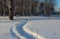 Winter travel the narrow road through the drifts in winter, the Siberian forest, the traces of the snowmobile on snow