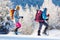 winter trekking. two girls with backpacks and snowshoes. walking in the snow among the trees. winter hike in the mountains.