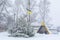 Winter in the Ukrainian village. Green tree crushed by snow