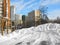 Winter urban landscape, houses, large snowdrift on sports ground, clear day