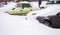 Winter urban view. Cars covered with snow on the city streets.