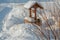 Winter village landscape. Wooden well with a winch in the snowdrifts. An old and rare water extraction device.frosty day