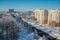 Winter Voronezh cityscape. Frozen trees in a forest covered by snow and hoarfrost near modern houses in the city of Voronezh