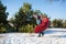 Winter walk in the forest. A guy in a red plaid plaid poses like a superhero, considering that the plaid is his cloak. The