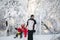 Winter walk: parents sledding with their son. A father pulls a sled with a young son on a snowy day, and a mother pushes