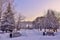 Winter walk through the snow-covered city park at sunset