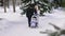 Winter walk. Young family walking in the winter park. She rolls the baby in the stroller. Fresh air is very useful for