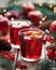 Winter warm drink. Cranberry orange pomegranate punch or mulled wine, sangria wooden table. Christmas tree decorations.