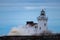 Winter waves striking a lighthouse and entrance light.