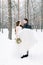 Winter wedding couple, bride and groom at their winter wedding day. Handsome groom holds her bride on hands