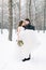 Winter wedding couple, bride and groom at their winter wedding day. Handsome groom holds her bride on hands