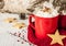 Winter whipped cream hot coffee in a red mug with cookies
