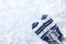 Winter white background with white and blue striped mittens, twigs, one big snowflake and copy space.