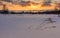 Winter, white snowdrifts, side view of a wooden house at sunset, pink sky, sunset