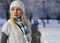 Winter woman with knitted hat and scarf over alley trees