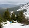 Winter wooded mountains. Male freeriding on snowboard. Mountain countryside for backcountry snowboarding and ski-touring