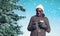 Winter young smiling african man enjoying listening music on smartphone with paper cup of coffee over christmas tree snowflakes