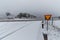 A wintery cross road with a sign