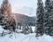 Wintery snowcovered mountain road with white snowy spruces. Wonderful wintry landscape. Travel background. Transportation