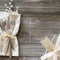 Wintry Christmas Table Place Setting with Snowflake napkin, Silver present with white bow and berries, all on rustic wood boards b
