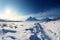 A wintry scene, snow clad landscapes, mountains on the horizon