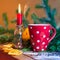 Wintry steaming hot cup of tea with candle and oranges